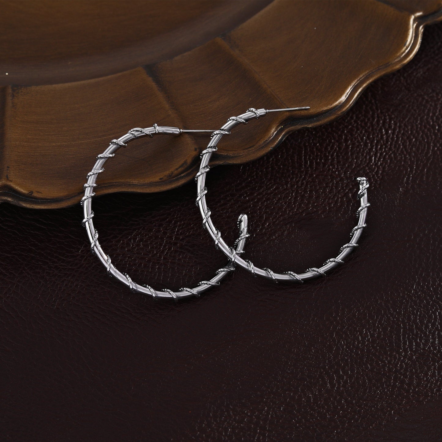 Boucles d'oreilles créoles ELNA argentées avec une torsade décorative