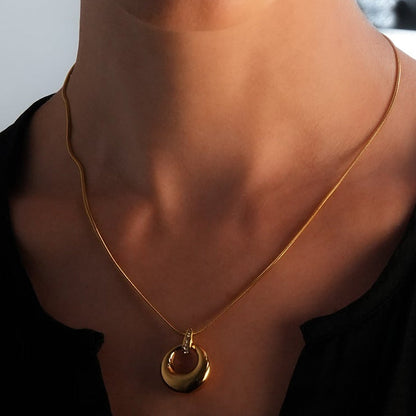 ALBASIMI : Chaîne peau de serpent avec fermoir serti d'oxydes de zirconium (CZ) et pendentif cercle asymétrique.