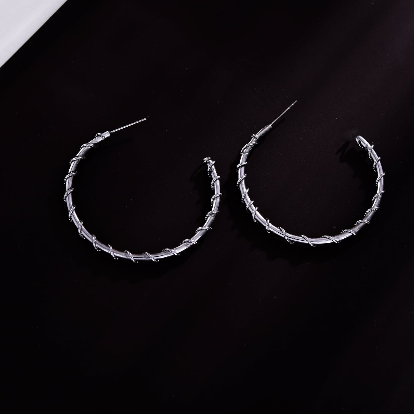 Boucles d'oreilles créoles ELNA argentées avec une torsade décorative