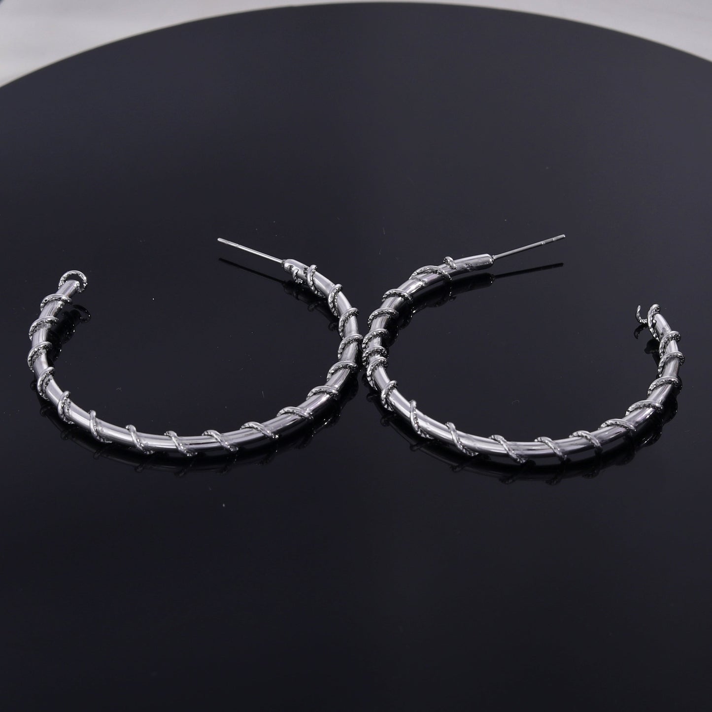 Boucles d'oreilles créoles ELNA argentées avec une torsade décorative