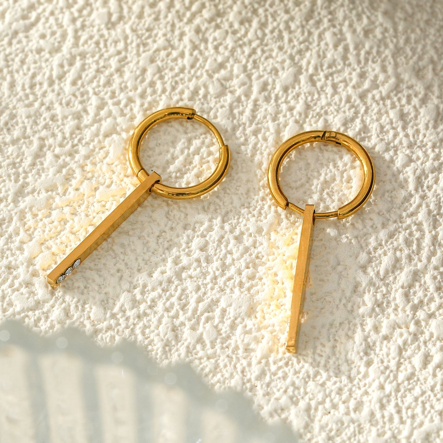 Style MAYLA : Créoles dorées au charme minimaliste, rehaussées d'un trio de zircons.